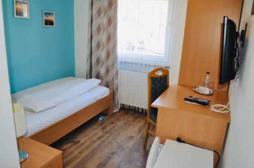 斯图加特迪斯卡夫酒店的小房间设有一张床和一张书桌