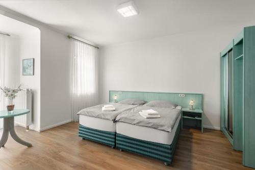 埃尔策帕潘霍夫阿姆贝特酒店的一间卧室配有一张带绿色床头板的床