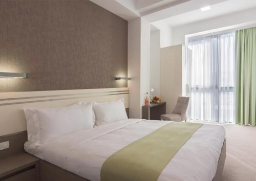 埃里温Dave Hotel Yerevan的一间卧室设有一张大床和一个大窗户