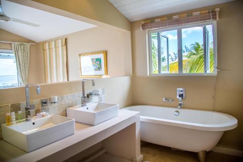 特鲁欧克比赫斯白橡树别墅的一间带两个盥洗盆、浴缸和窗户的浴室