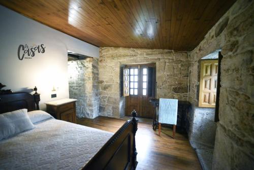 钱塔达As Casas Ribeira Sacra的一间卧室设有一张床和木制天花板