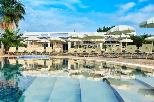 卡洛维诺里瓦滨海度假村 - CDS酒店的一个带椅子和遮阳伞的游泳池