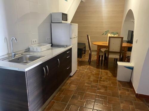 阿尔戈多纳莱斯Apartamentos Algodonales的一间带水槽和餐桌的厨房以及一间用餐室