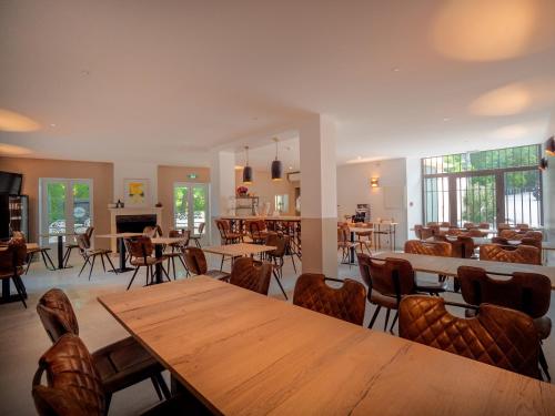 马洛塞讷Hôtel & SPA Ventoux Provence "Domaine des Tilleuls"的用餐室配有木桌和椅子