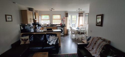 阿罗柴尔Ben Lomond Cottage的带沙发的客厅和厨房