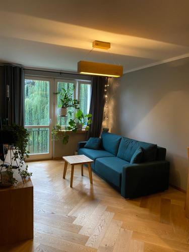 博赫尼亚Apartament Krakowska的客厅配有蓝色的沙发和桌子
