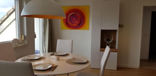 明登Drosselnest Moderne Design-Wohnung Alles neu!的白色餐桌、白色椅子和绘画