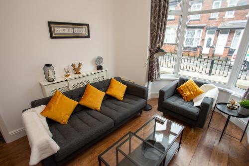 Ford GreenBirches House的客厅配有黑色沙发和黄色枕头