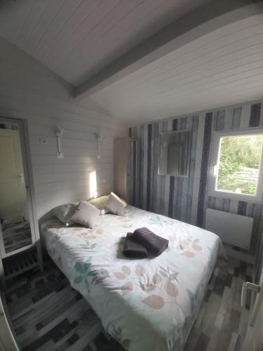 拉特斯特德布赫Chalet T3/clim/wifi/pkg/terrasse/15 min plages的一间卧室配有一张床,床上有浴袍