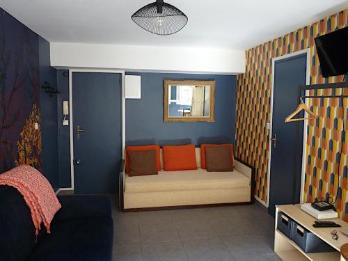 马赛LE LOGIS DU PALAIS的一间配备有橙色枕头的沙发的客房