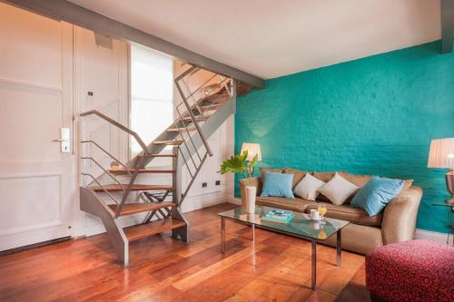 布宜诺斯艾利斯San Telmo Suites的带沙发和楼梯的客厅