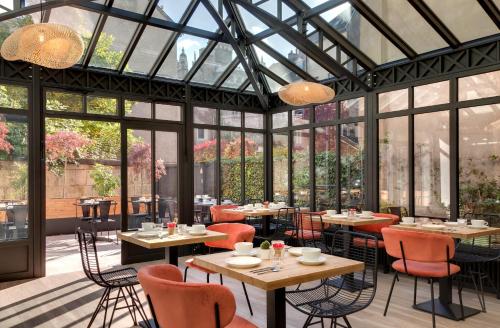 第戎杜克斯酒店 的餐厅设有桌椅和窗户。