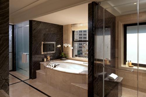 纽约纽约半岛酒店的带浴缸、电视和窗户的浴室。