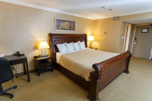 道森克里克The George Dawson Inn & Conference Centre的酒店客房设有一张大床和一张书桌。