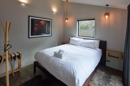 特卡波湖Designer Cabin - Lake Tekapo的卧室配有一张大白色床和窗户
