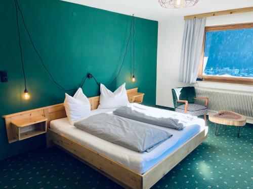 富尔普梅斯Königin Serles - großzügig, gemütlich & nachhaltig的一间卧室配有一张带绿色墙壁的床