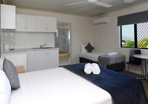 汤斯维尔高峰汽车旅馆的一间带白色大床的卧室和一间厨房