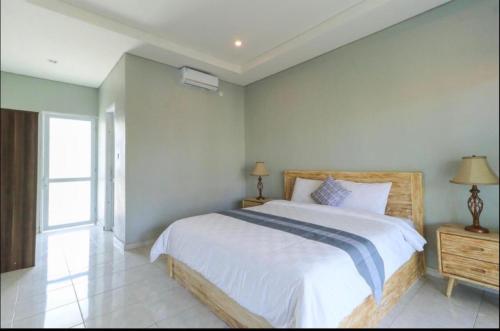 坎古Anyar Guesthouse Canggu的卧室设有一张白色大床和一扇窗户。