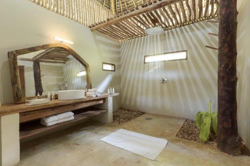 米查维Upendo Beach Boutique Hotel Zanzibar的一间带水槽和镜子的浴室