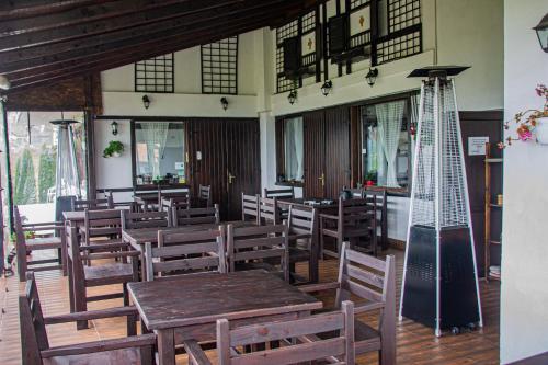 佩什泰拉Pensiunea Casa Boiereasca的餐厅设有木桌、椅子和窗户。