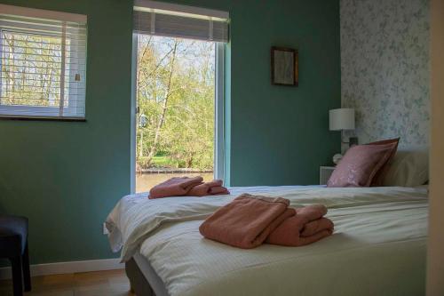 羊角村Farmhouse Lodge Giethoorn的一间卧室配有一张大床和毛巾