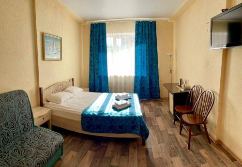 沃罗涅什Hotel Nord的酒店客房,配有床、桌子和椅子