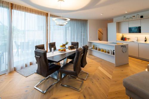 滨湖新锡德尔Seehaus SeeZeit - Am Hafen的厨房以及带桌椅的用餐室。