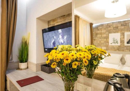 地拉那Hotel Artist的客厅设有黄色的鲜花和电视