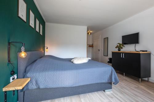 德科克斯多普DOCK10TEXEL的一间卧室配有蓝色的床和一台平面电视