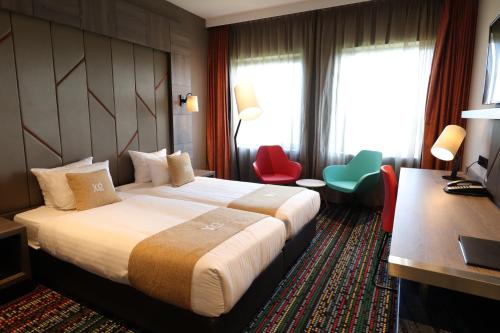 阿姆斯特丹XO酒店时尚店的酒店客房,配有一张床、一张桌子和椅子