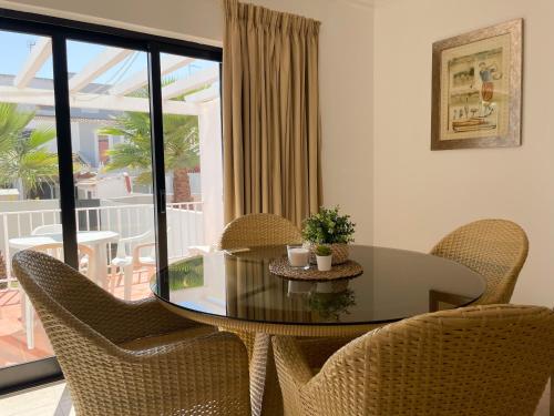 维拉摩拉Mouraliz Apartments by HD PROPERTIES - Vilamoura Marina的一间设有玻璃桌和椅子的用餐室