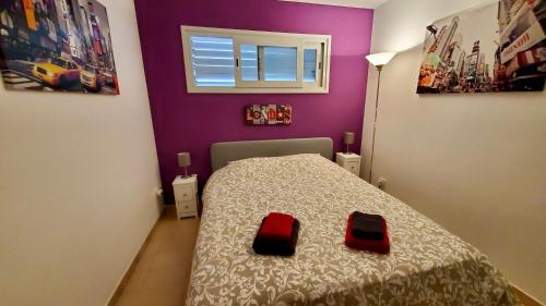 罗列特海岸Apartments Paradise Lloret的一间小卧室,配有一张带两个红色垫子的床