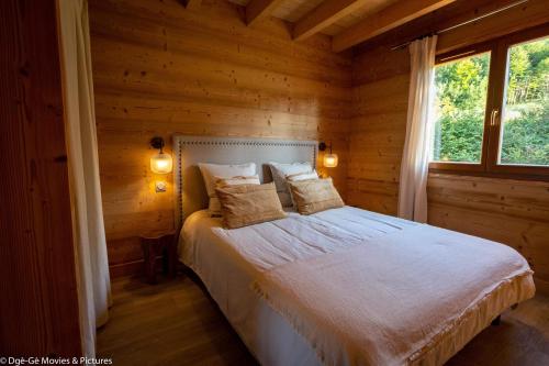 BonlieuLes Jardins du Hérisson Chalet 1的小木屋内一间卧室,配有一张床