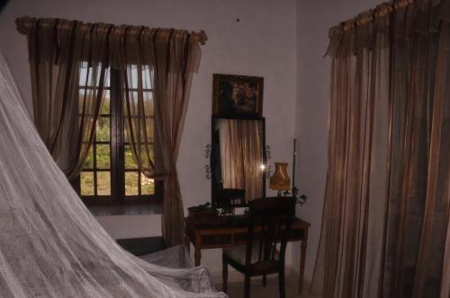 Douar Doukkaraferme Walila的一间卧室配有书桌和一张带窗帘的床