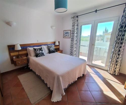 塔维拉Casa Morgado的一间卧室设有一张床和一个大型滑动玻璃门