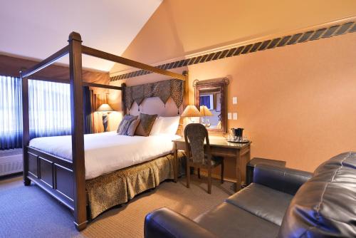 弗农Prestige Vernon Hotel的酒店客房配有1张床、1张书桌、1张床和1张沙发。