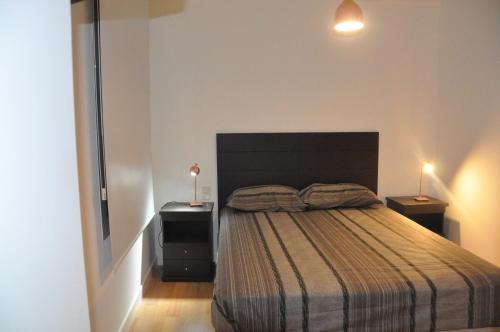 布宜诺斯艾利斯Moderno departamento en el Corazon de Recoleta的一间卧室配有一张带2个床头柜和2盏灯的床。