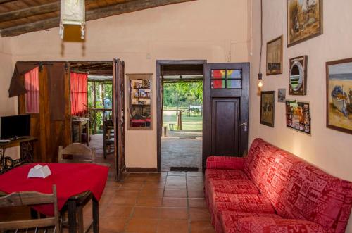 皮里亚波利斯Hostel Mar y Campo的客厅配有红色的沙发和桌子