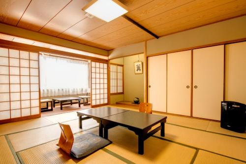 奈良Nara Hakushikaso的客房设有桌椅和窗户。