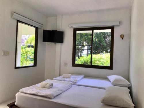 董里LayTrang Pakmeng Marina Spa and Resort的带2扇窗户的客房内的2张床