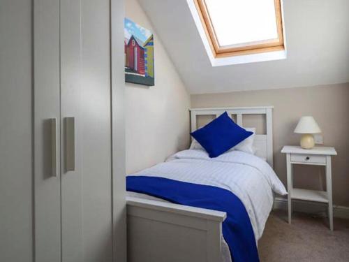 兰迪德诺Royal Manor Park的一间卧室配有一张带蓝色床单的床和一扇窗户。