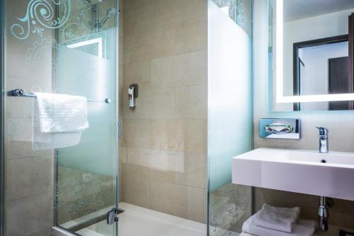 日内瓦VISIONAPARTMENTS Geneva Mont-Blanc的一间带玻璃淋浴和水槽的浴室
