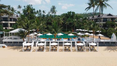 波普托Anantara Bophut Koh Samui Resort的海滩上带椅子和遮阳伞的海滩