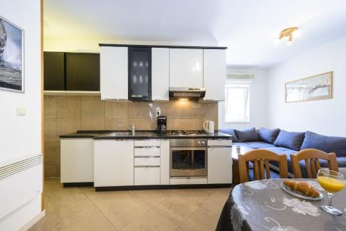 杜布罗夫尼克Apartment Tija的厨房以及带沙发和桌子的客厅。
