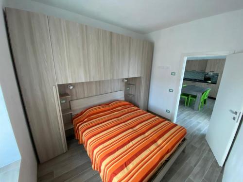 莱维科特尔梅Appartamenti Nadalini的一间卧室配有一张带橙色条纹毯子的床