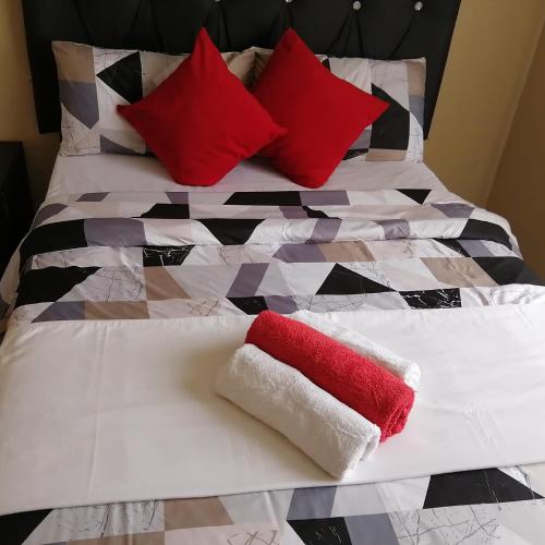 威特班克ROYAL LODGE的一张带红色和白色枕头的床