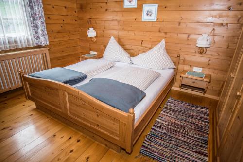 列兴BIO-Bergbauernhof Ederhias的木制客房内的一间卧室,配有一张床
