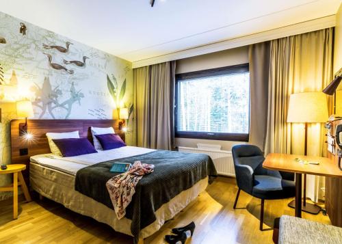 耶夫勒斯堪迪克加弗勒瓦斯特酒店的配有一张床和一张书桌的酒店客房