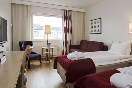 诺尔雪平斯堪迪克诺尔雪诺德酒店的酒店客房,配有床和沙发
