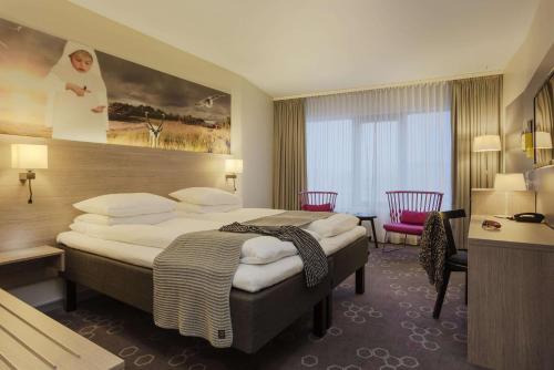 纳尔维克纳尔维克斯堪迪克酒店的酒店客房设有一张大床和一张书桌。